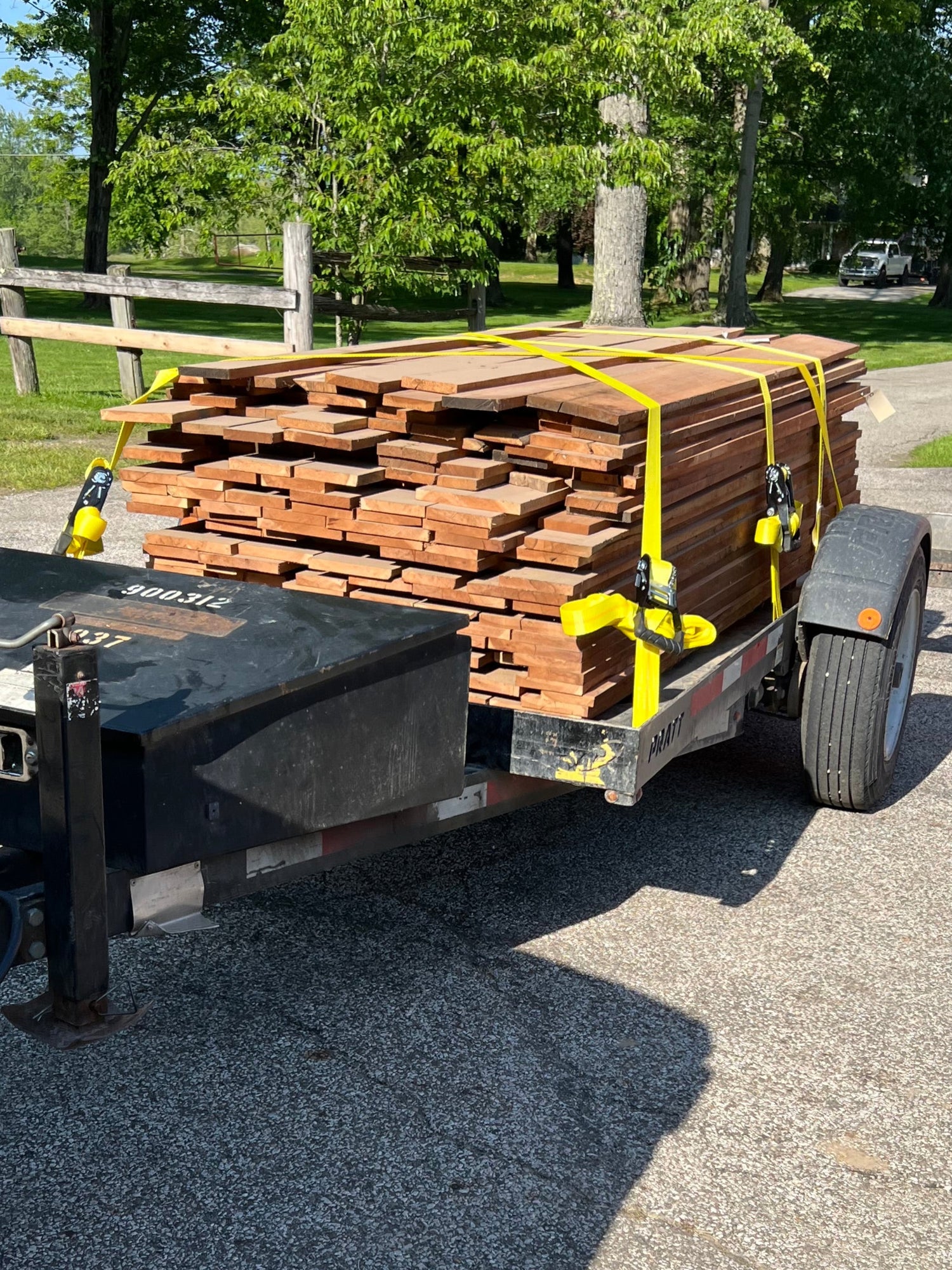 Truck bed with stacked wooden planks on a driveway
